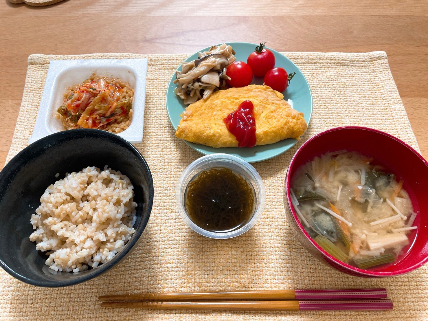 ボディメイク食事例（納豆キムチ、もずく、玄米ご飯、えのきとわかめの味噌汁、キノコ炒め、ミニトマト、オムレツ）